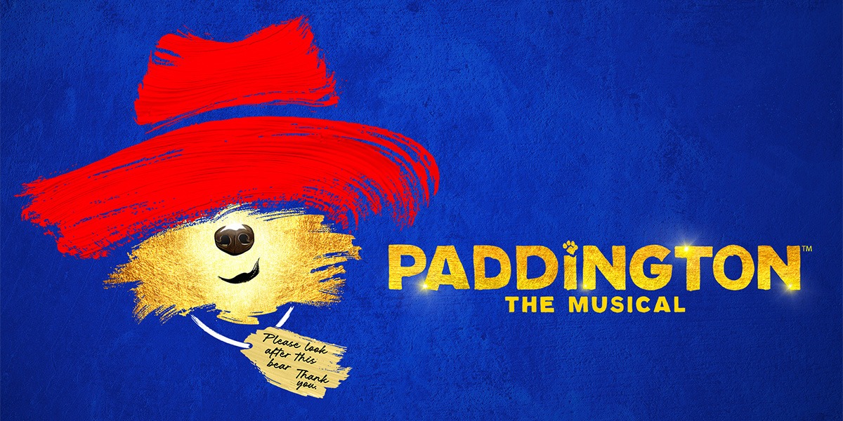 The background is royal blue. On the left it reads 'Paddington the musical' in gold letters. On the right is an image of Paddington Bear