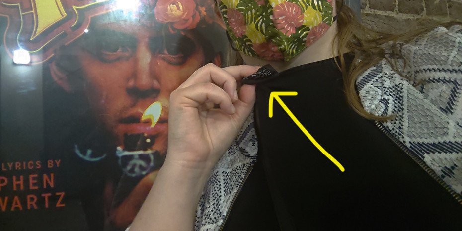 A close-up photo showing the label of a tshirt, with it being accidentally worn back to front