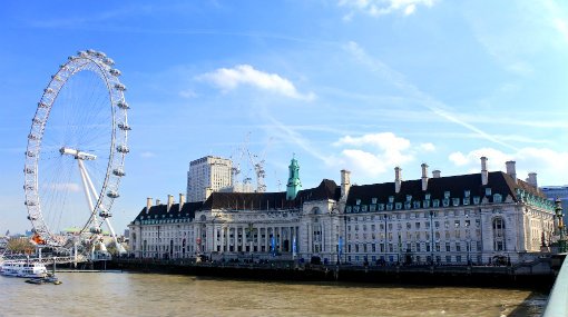 The courtroom at London County Town Hall, featuring wooden benches, ornate details, and dramatic lighting.