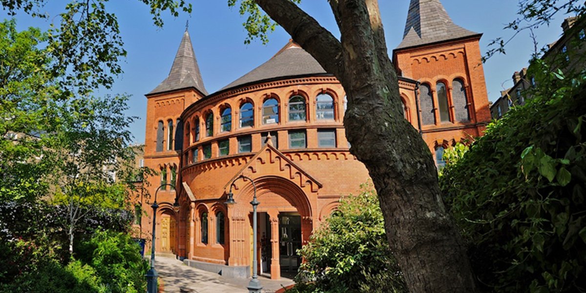 The Tabernacle Theatre exterior features a brick façade, large windows, and a prominent entrance with signage.
