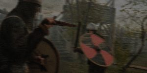 two people wearing armour are in combat. One holds a silver sword, the other a red and silver shield.