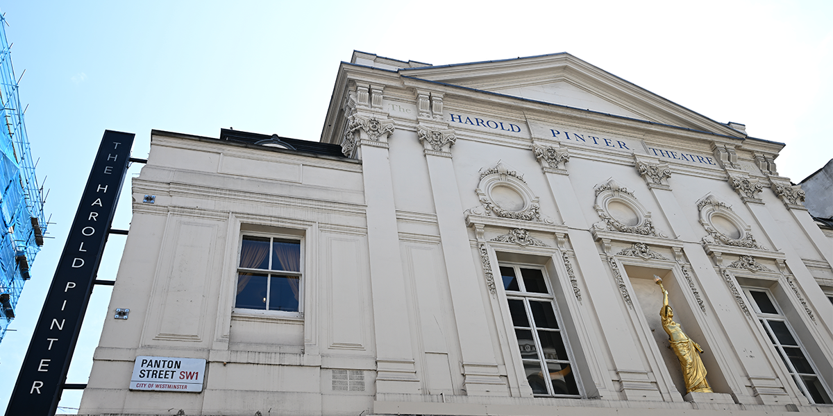 The Harold Pinter Theatre features a red brick exterior with large glass doors and a vibrant marquee.