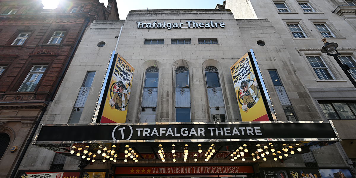 A stage set for "The 39 Steps" featuring wooden props and a red curtain backdrop.